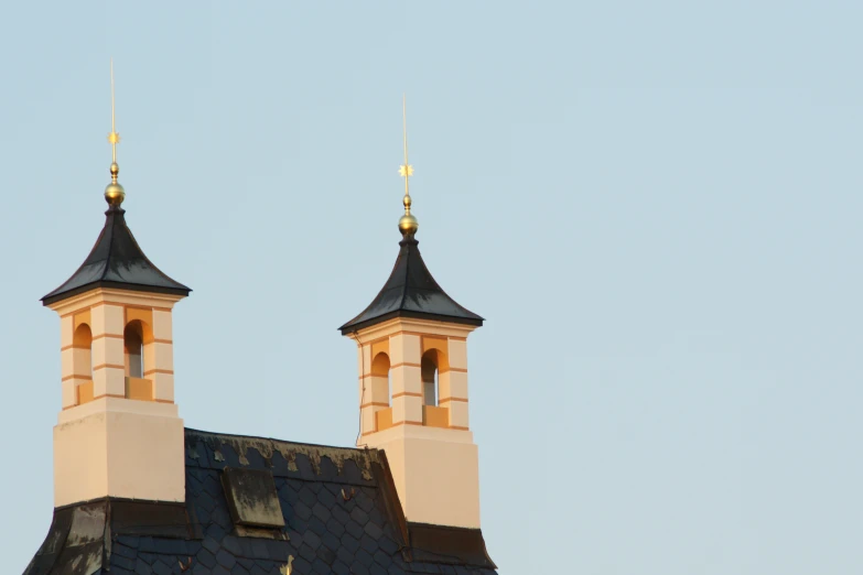 two spires on top of a building against a sky