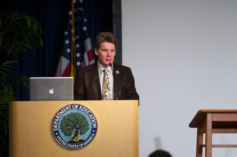 a man standing in front of a podium with a laptop