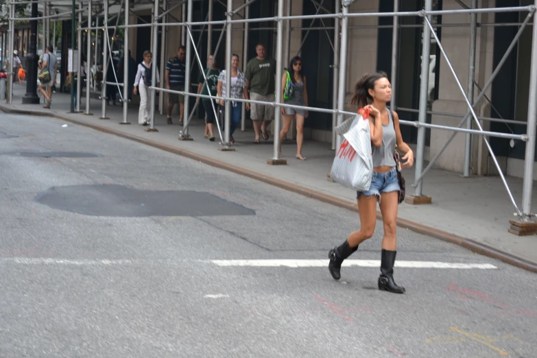 a lady walking down a city street in high boots