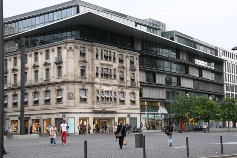 a group of people walking past a tall building