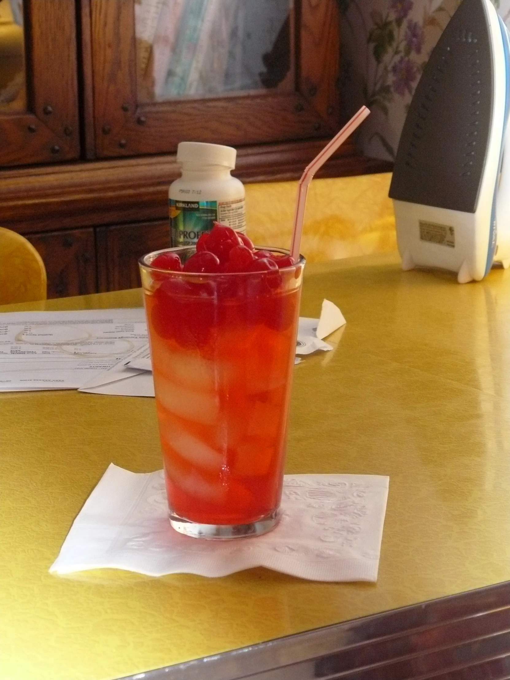 a red drink on a counter with a straw