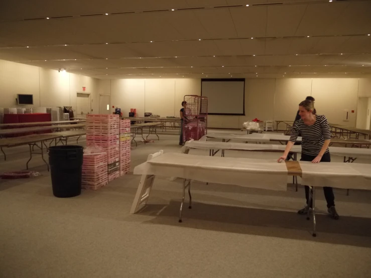 woman standing in a large room with a lot of empty tables