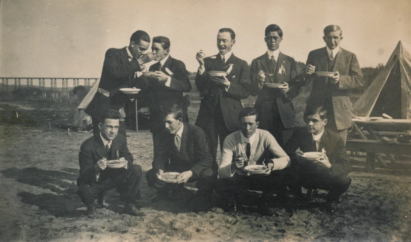a group of men eating from bowls and plates