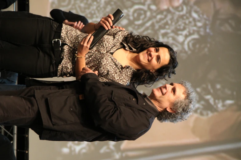 a man standing next to a woman holding an award