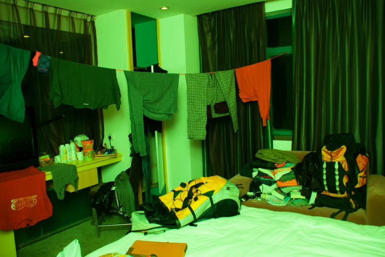 various bags on a bed and clothes drying in a room