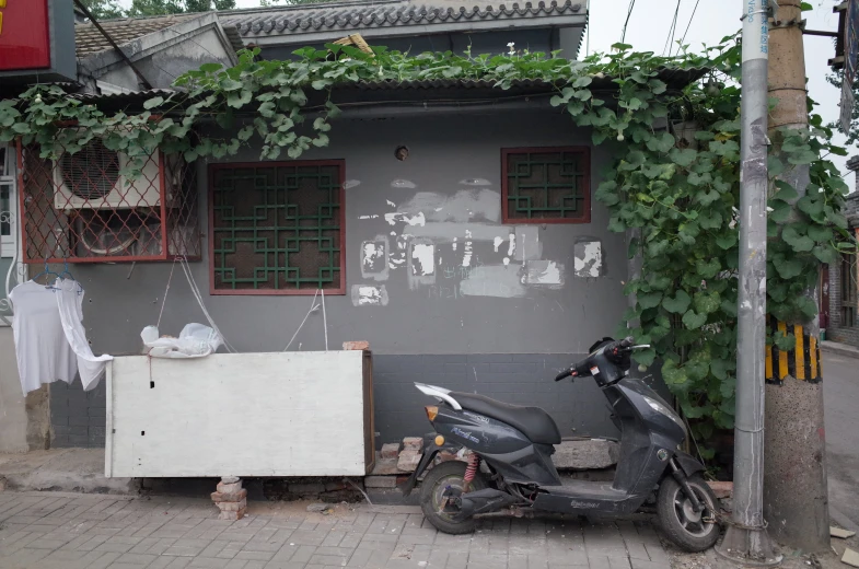 an image of a moped sitting outside of the house