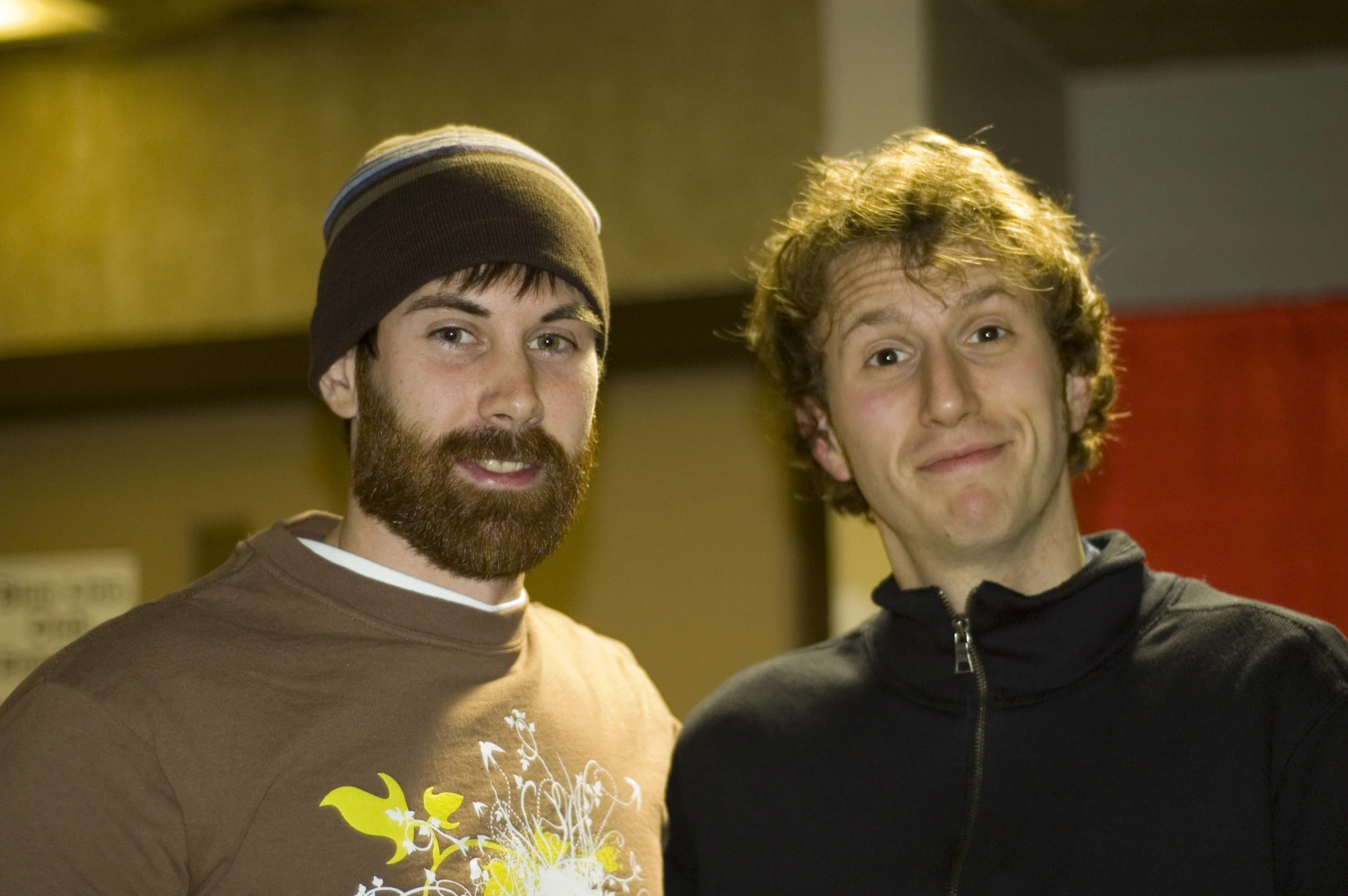 two men standing next to each other, one with red hair and the other with long beard