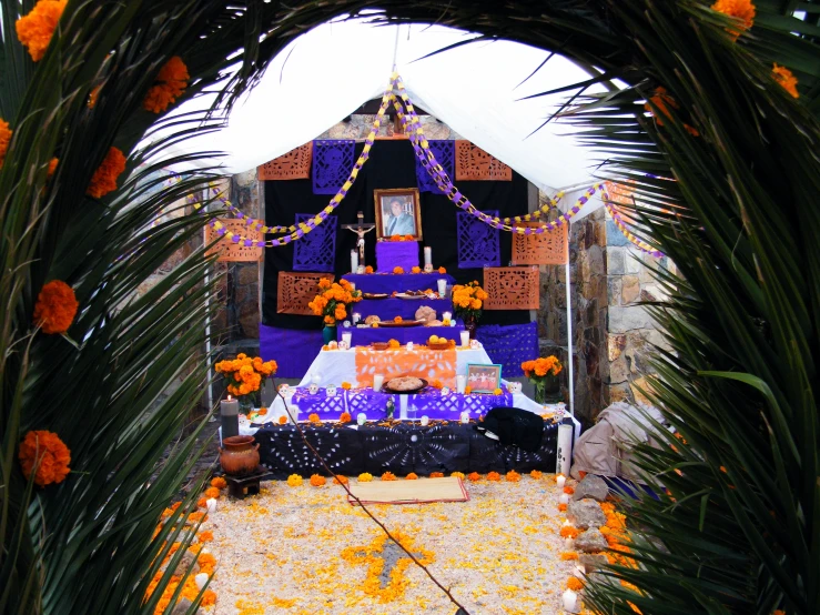 a colorful altar is decorated with flowers and greenery