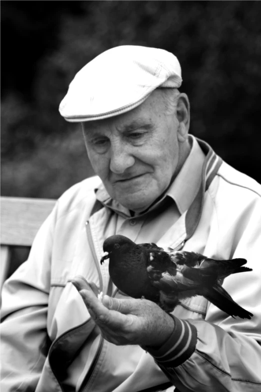 the old man is feeding two small birds