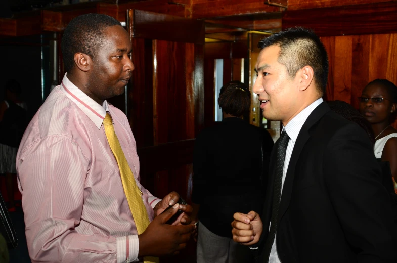 two african men talking to each other in a room