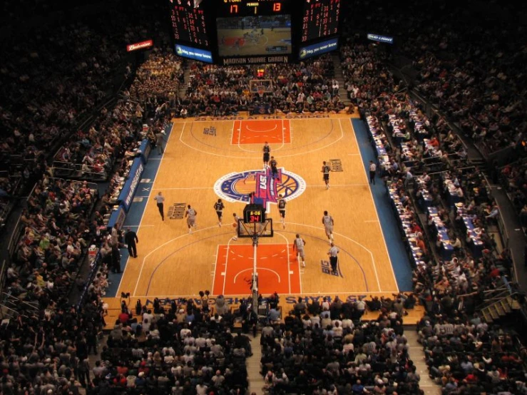 a basketball court with people watching and people on it