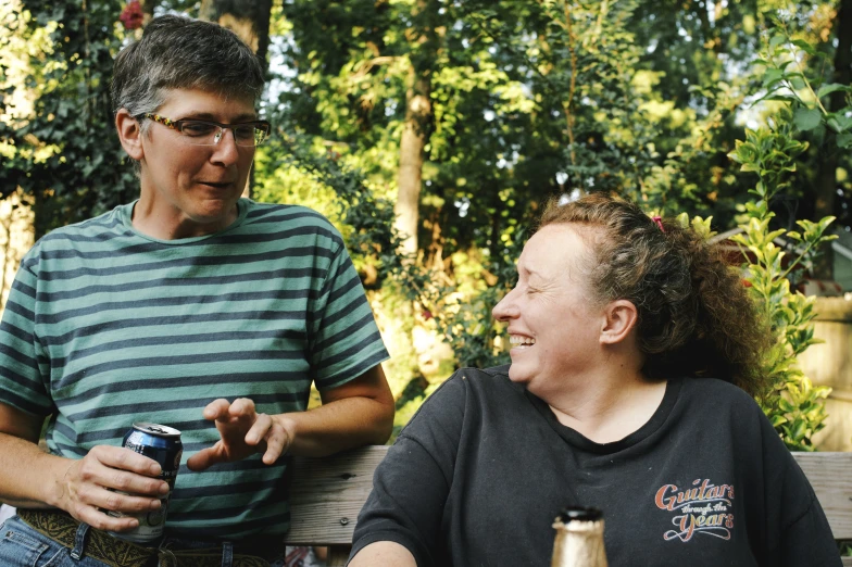 a woman in a green and black striped shirt sitting next to another woman