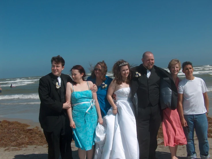 a group of people posing for a po in formal wear