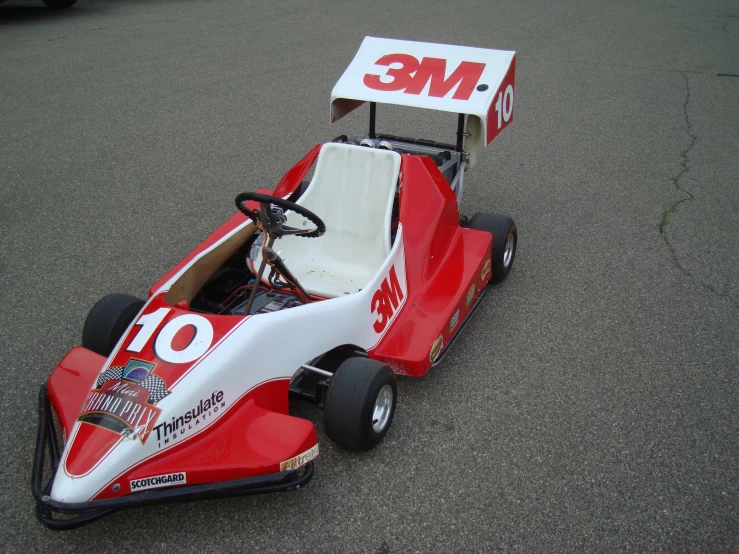 a red and white toy car driving down the street