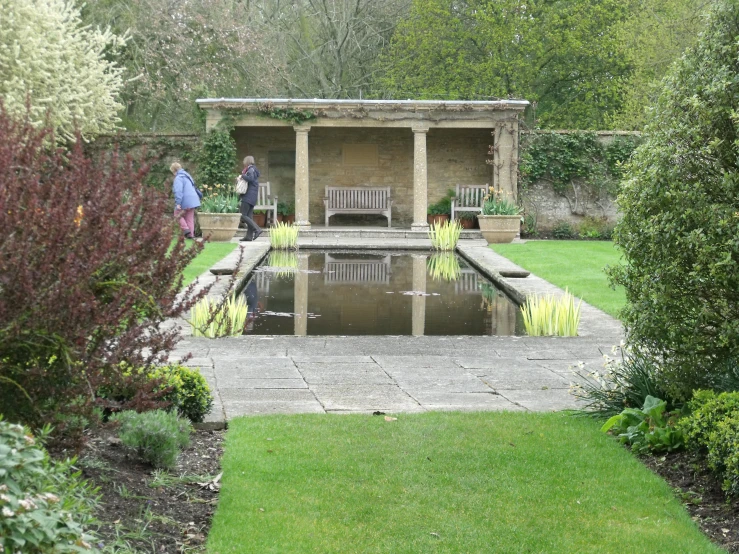 two men walking by a gazebo in a garden