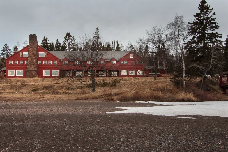 there is a red house with a black roof and snow in front