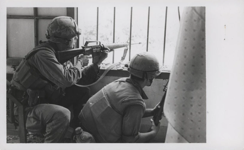 a man with a gun next to another man on a boat