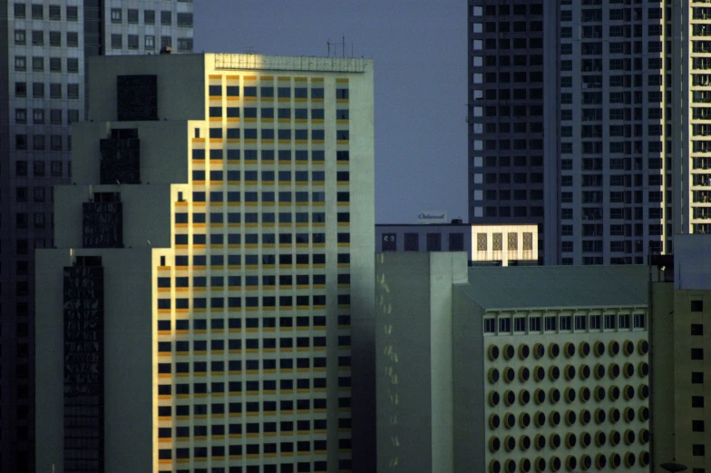 a night time scene showing tall buildings and traffic signals