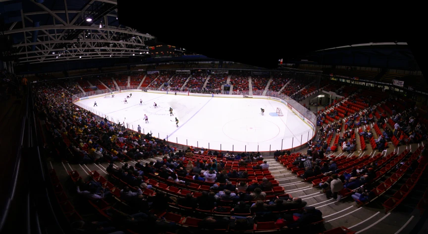 an ice hockey rink at night with fans