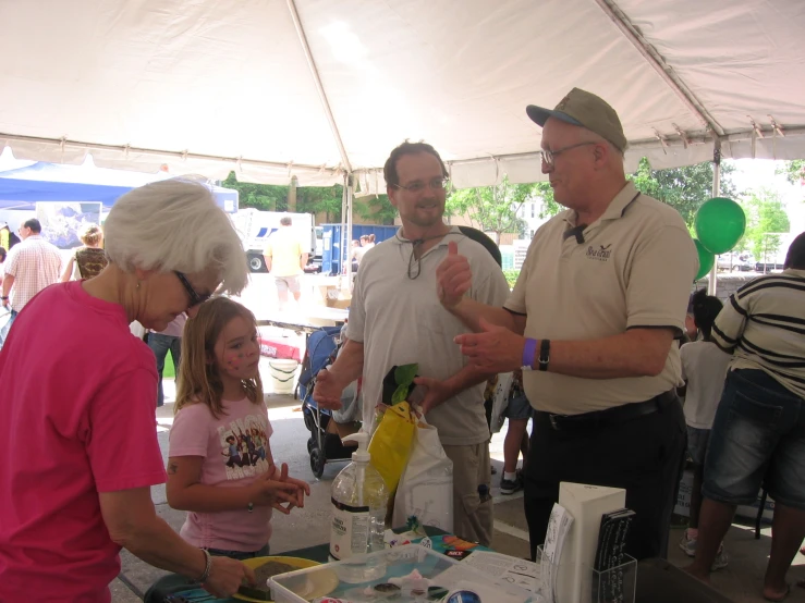 several people are having a drink under the tent