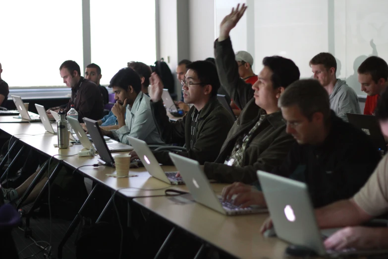 a bunch of people sitting in front of laptop computers