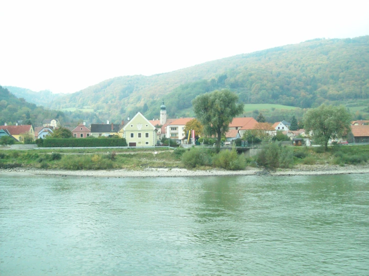 some buildings near the water with some hills in the background