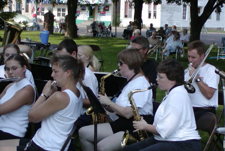 the people are playing their instruments in the park