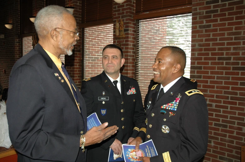 the two men in military uniforms have their hands folded