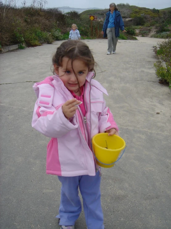 a  with a yellow bowl holds the lid of a plastic bucket