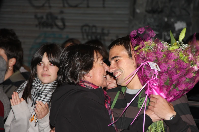 two people are kissing with flowers and confetti on their head