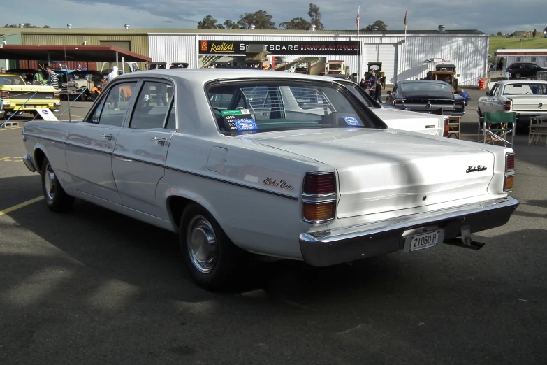 a vintage white car is parked in a lot