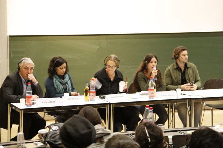 a number of people sitting at a table with beverages