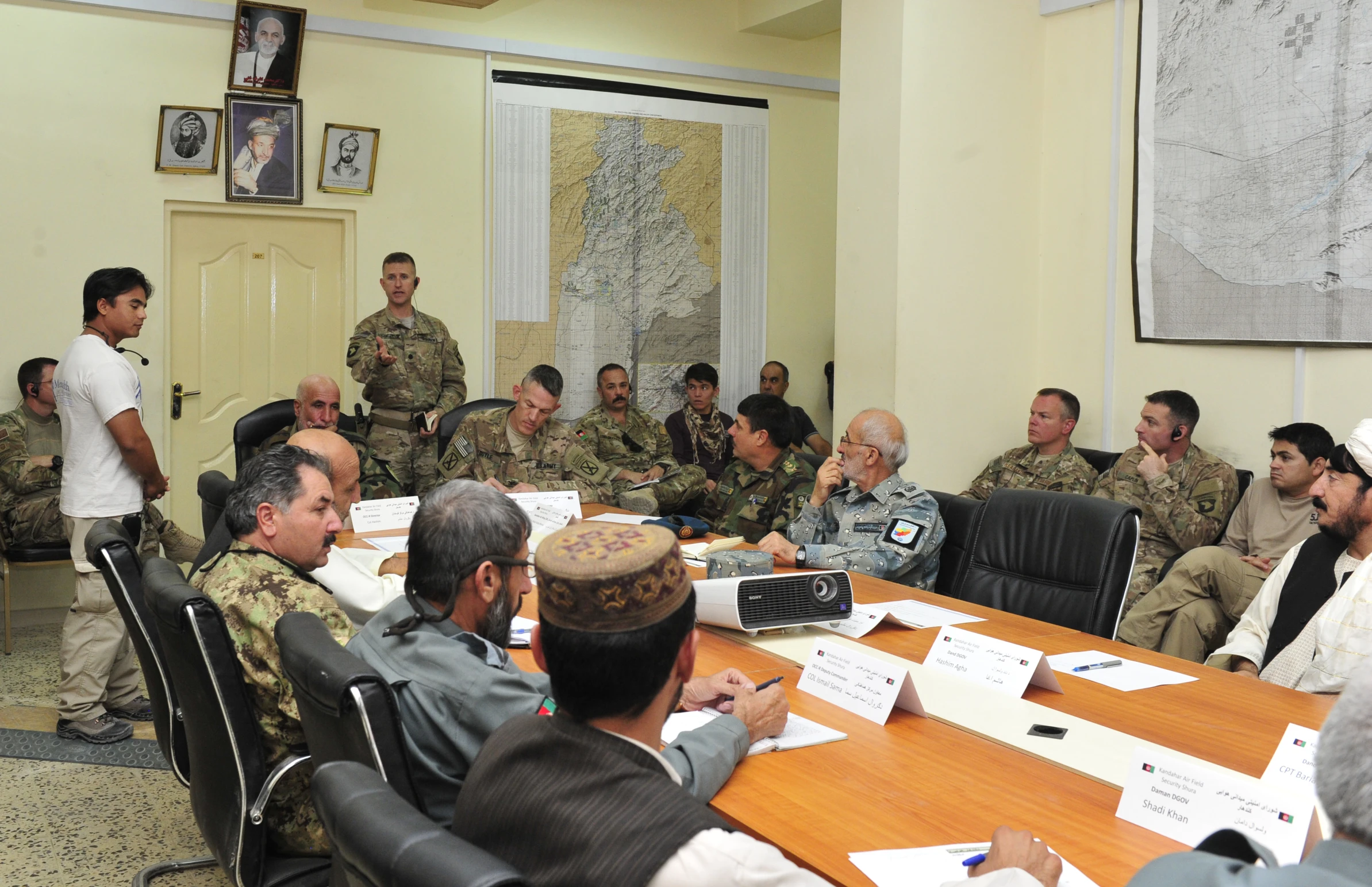 several men in uniforms sitting at a long wooden table with some papers