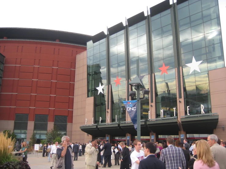 several people walking around near the entrance to an event