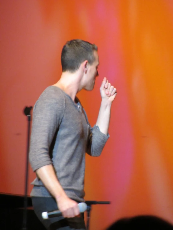 a man with his hand in his mouth on stage