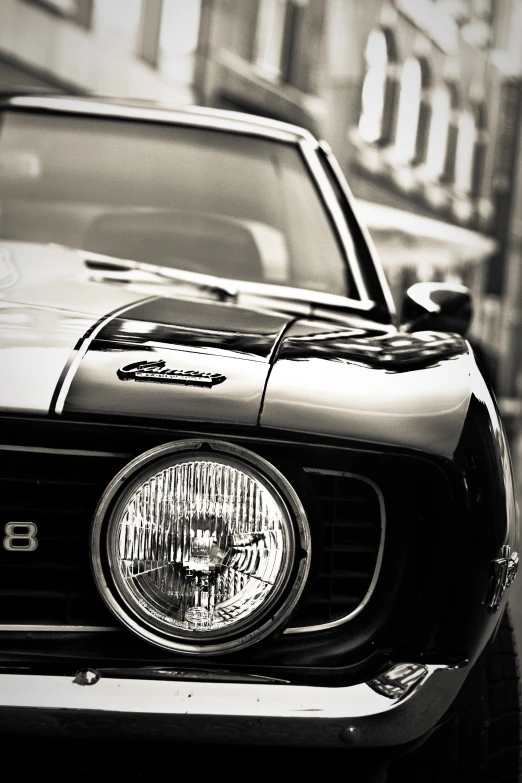 the front end of an old car parked in the street