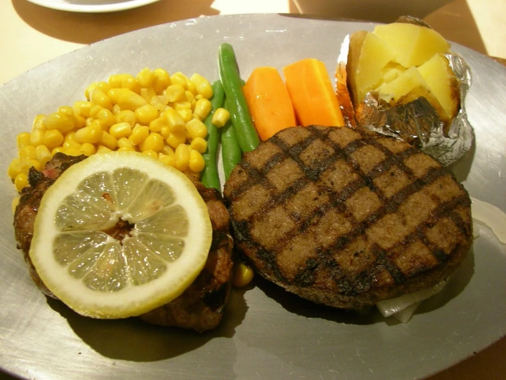 grilled steak, corn and carrots sit on a plate