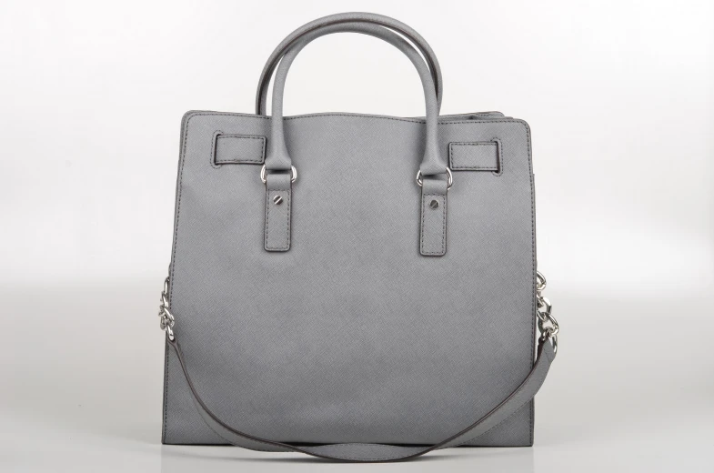 a gray purse that is sitting on a white table