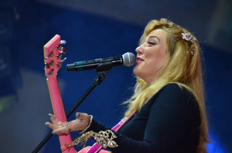 a woman on stage singing into a microphone