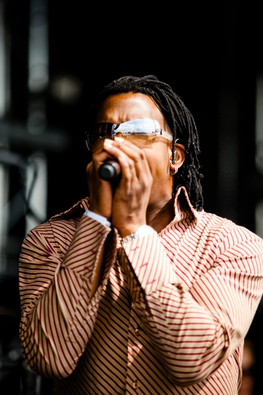 a man with dreadlocks on a stage holding a microphone in his hand