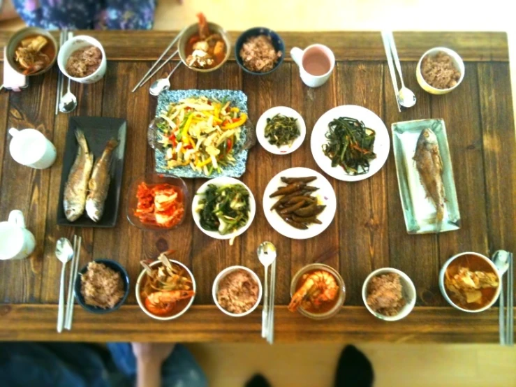 a table topped with many plates and bowls of food