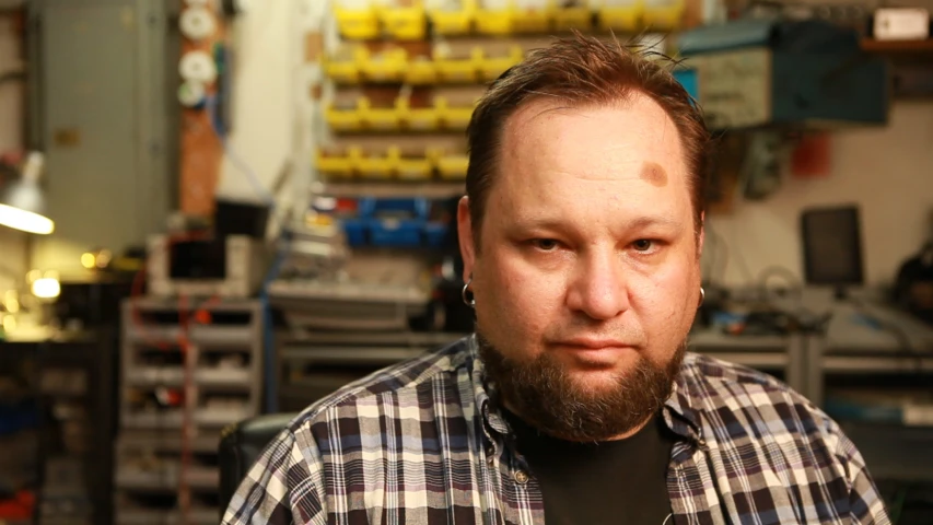 a man is posing for a picture in a workshop