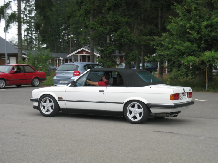 a white convertible parked in a parking lot