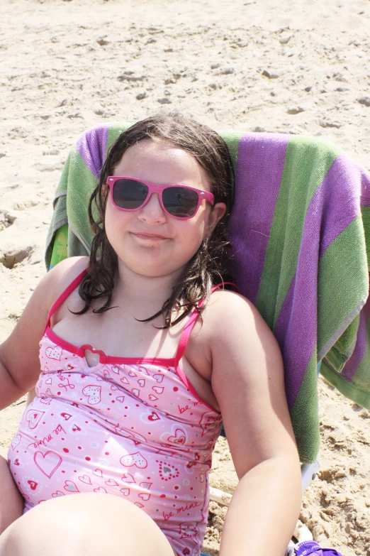 a  with sun glasses on in the sand