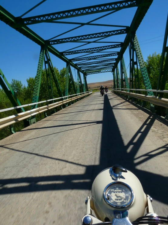 two motorcyclists passing each other on the bridge