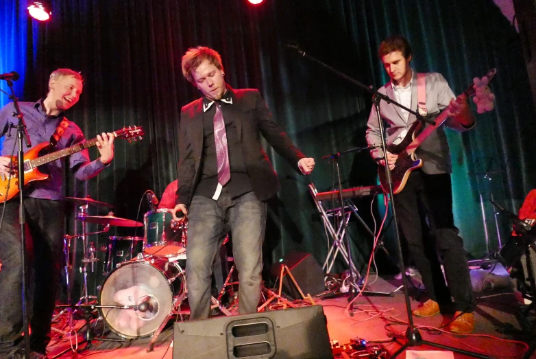 a group of men on stage with guitars