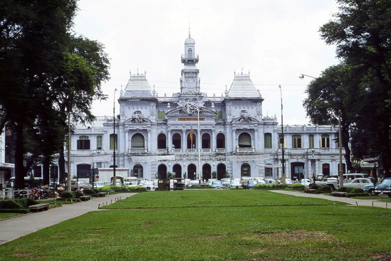 a large white building sitting on top of a lush green park