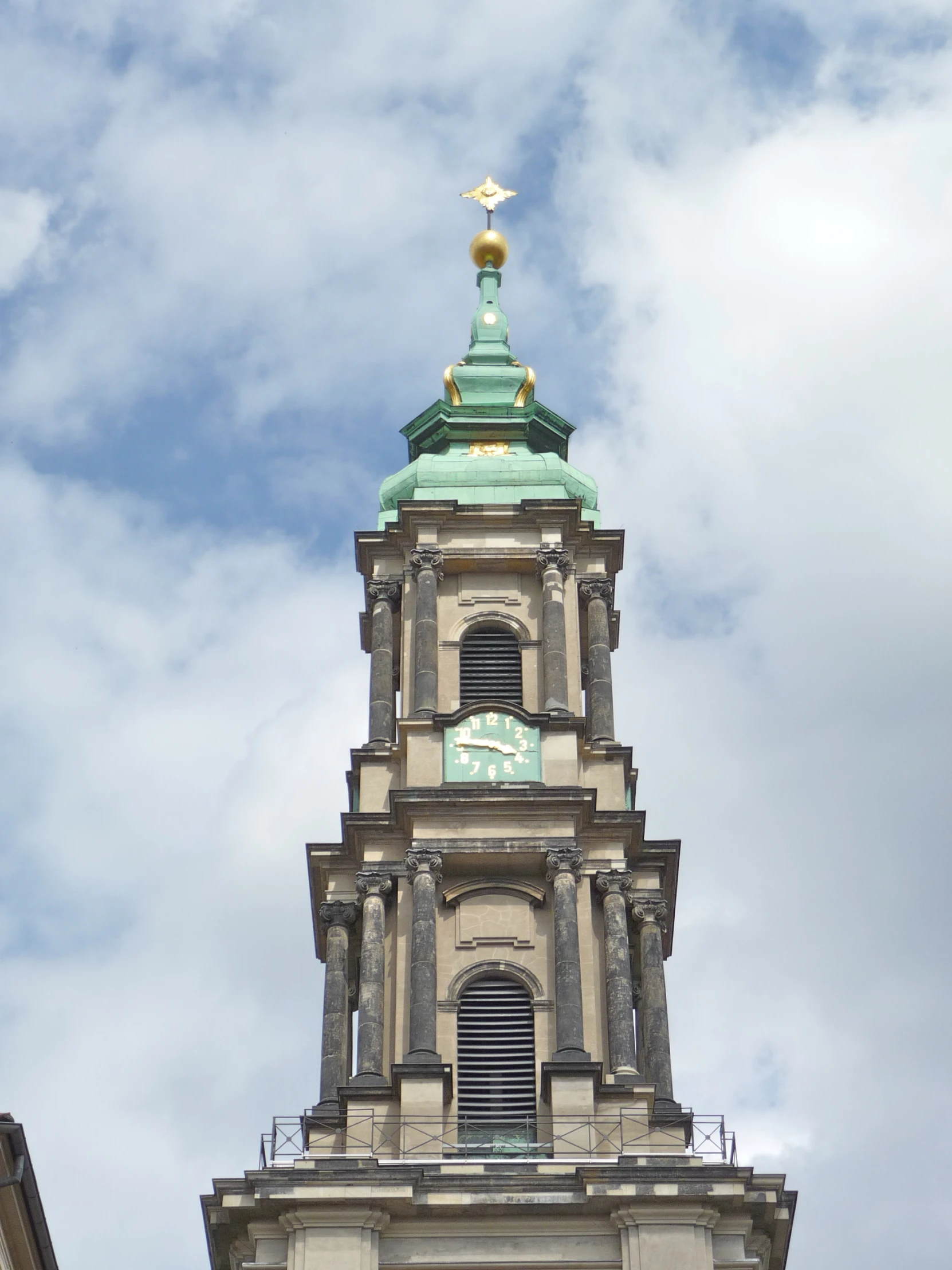 a clock tower stands against a cloudy sky