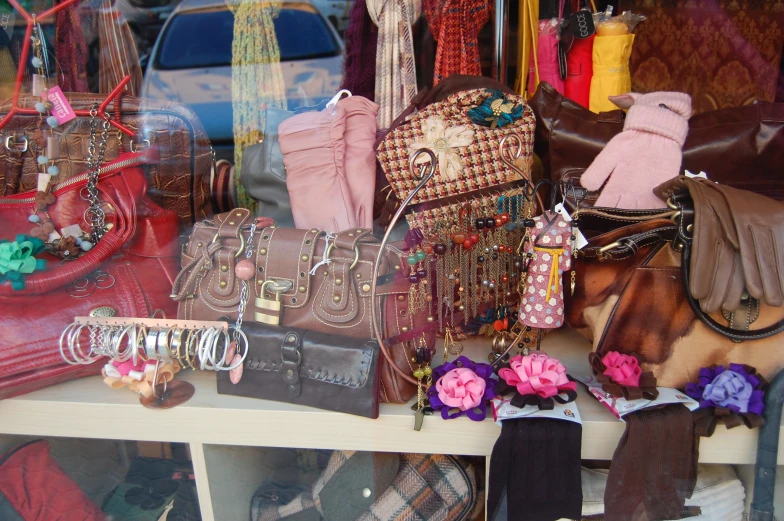 different types of handbags are on display behind glass