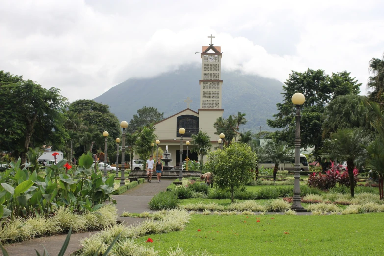 people standing on the grass in front of a clock tower